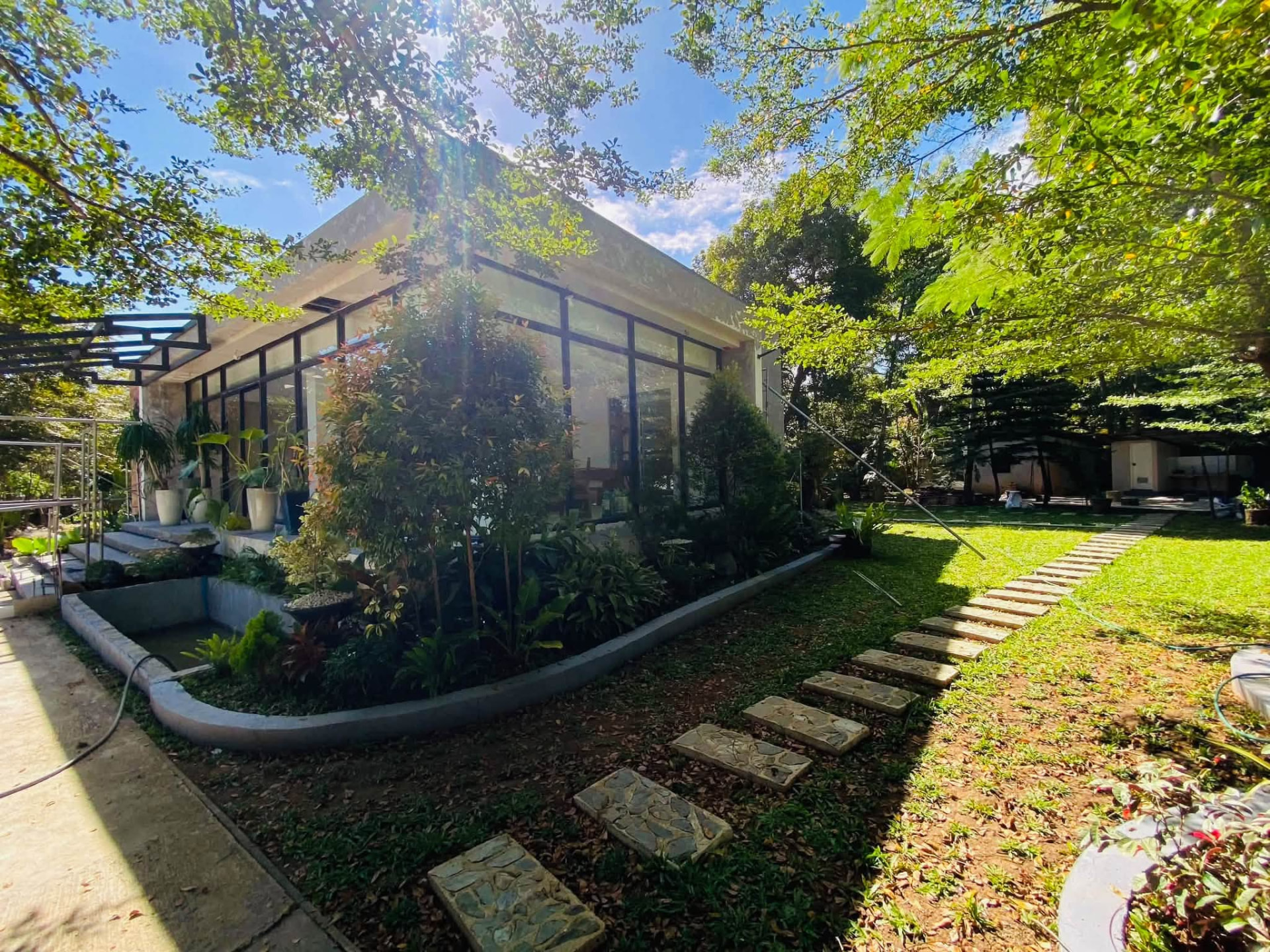 Side view of Casa Elena with glass windows and a pergola
